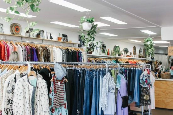a store filled with lots of clothes hanging on racks .