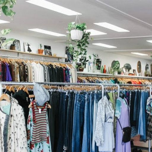 a store filled with lots of clothes hanging on racks .