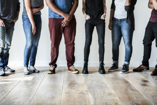 a group of people are standing next to each other on a wooden floor .