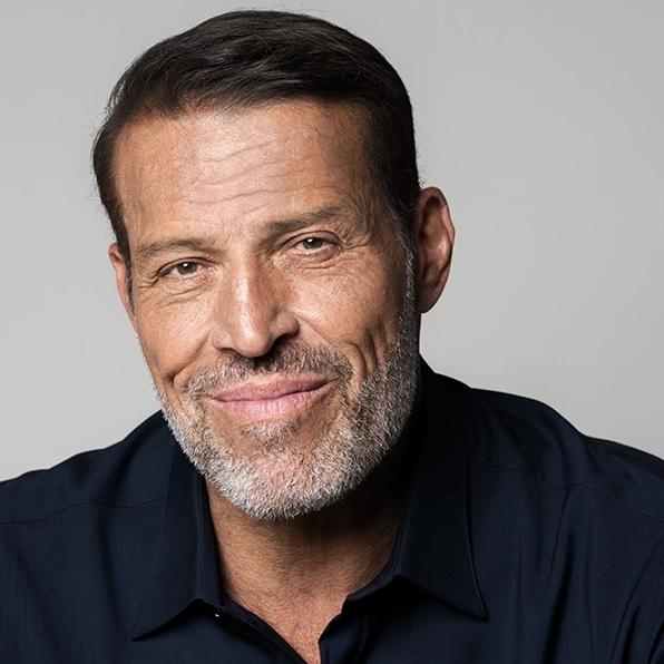 Tony Robbins with a grey beard smiling slightly.