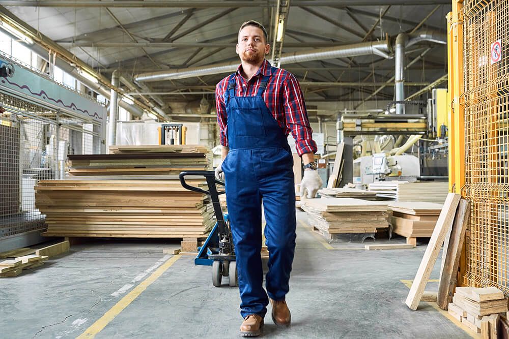 a man is pushing a hand truck in a factory .