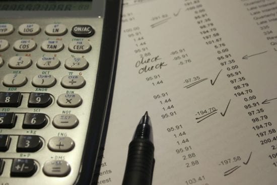a pen is sitting on top of a piece of paper next to a calculator .