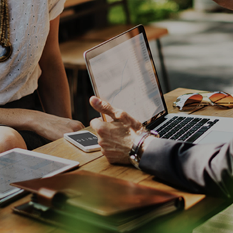 A playbook for entrepreneurs image of man opening laptop at desk with planner