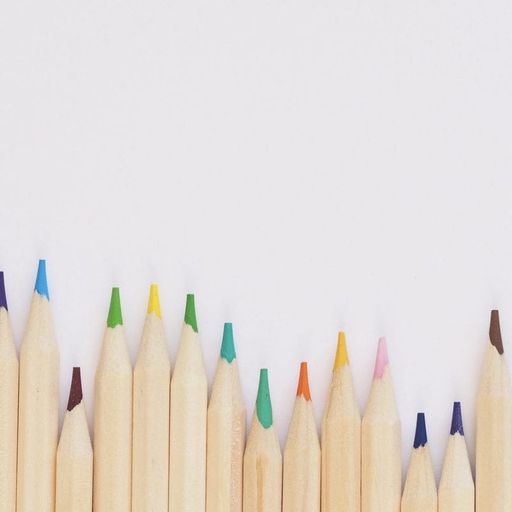 a row of colored pencils are lined up in a row on a white background .