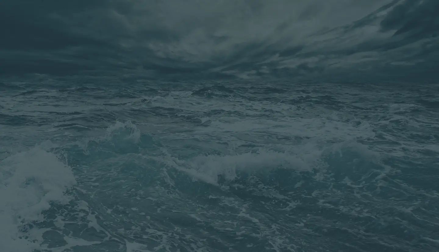 a large body of water with waves crashing against a cloudy sky .