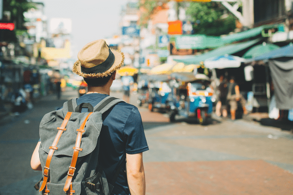 a man with a backpack is walking down a street