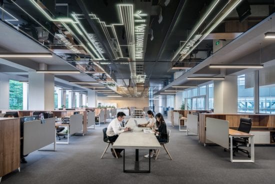 a group of people are sitting at a table in an office .