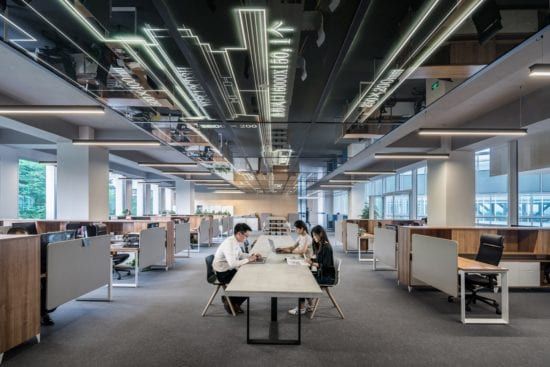 a group of people are sitting at a table in an office .