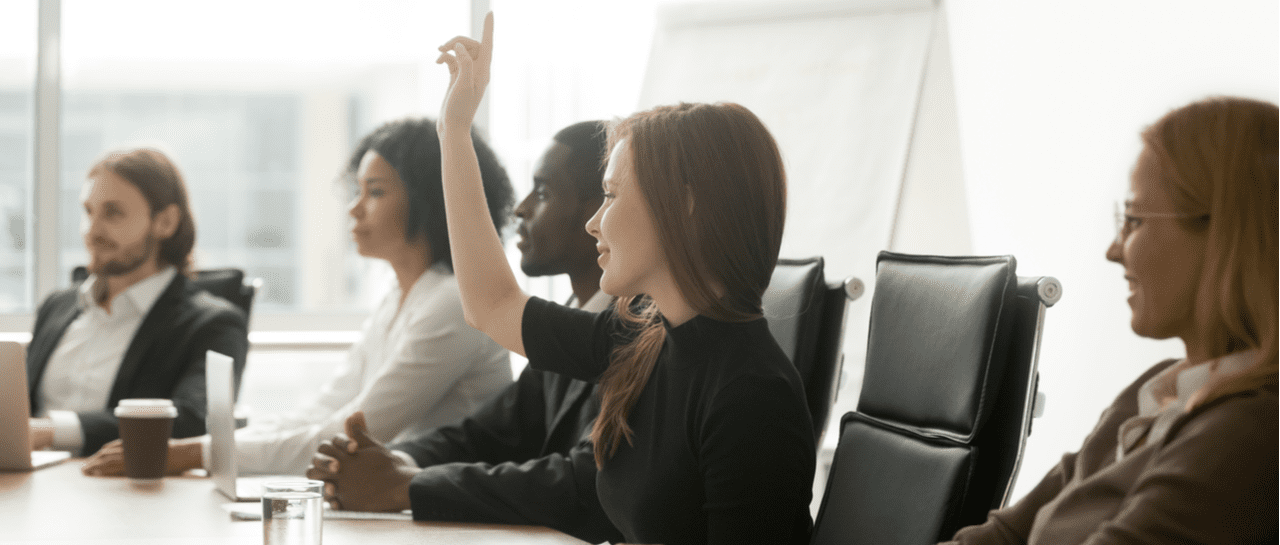 a woman is raising her hand to answer a question