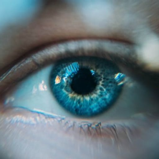 a close up of a person 's blue eye through a magnifying glass .