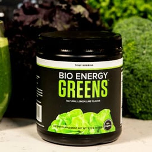 a jar of bio energy greens next to a glass of green juice .