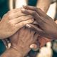A historic conversation for healing and unity image of a diverse group of people are putting their hands together