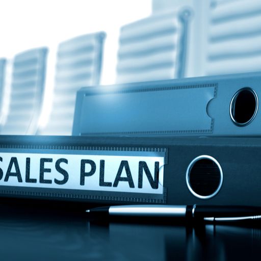 a sales plan binder with a pen on a table .