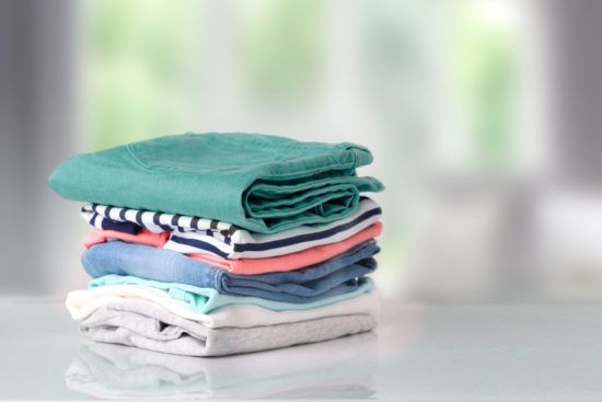 a pile of clothes is stacked on top of each other on a table .