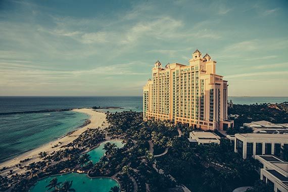 an aerial view of a large hotel on a tropical island next to the ocean .