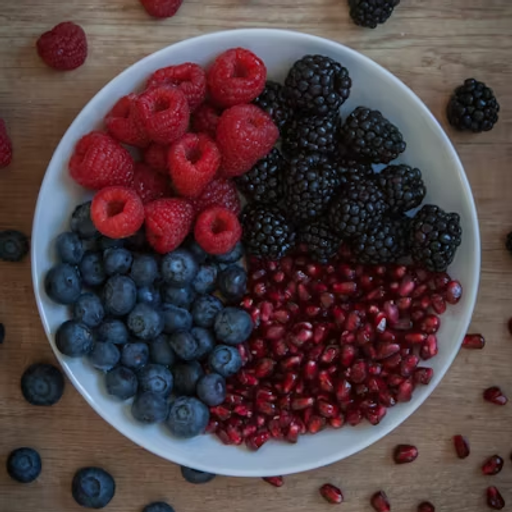 a white bowl filled with raspberries blueberries blackberries and pomegranate seeds