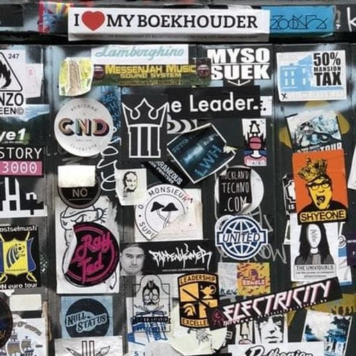 a wall covered in lots of stickers and graffiti .