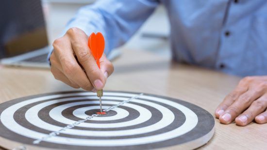 a man is hitting a dart in the center of a target