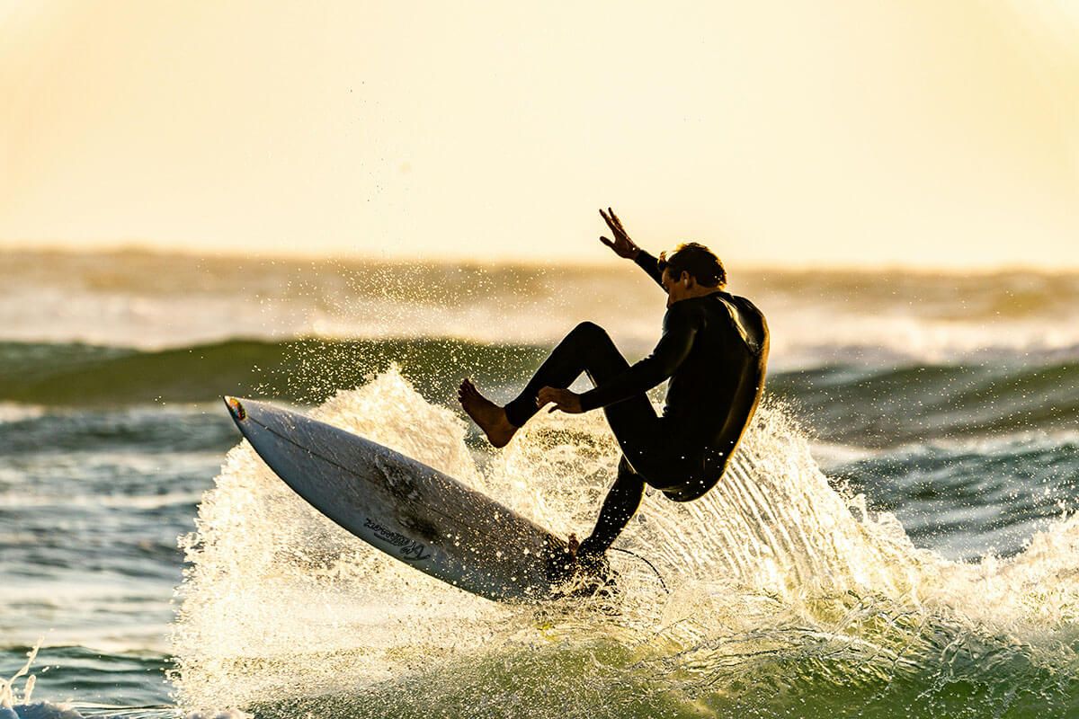 A man is riding a wave on a surfboard in the ocean .