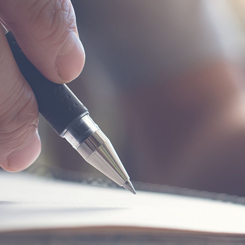 How to take charge of your business image of a person is writing on a piece of paper with a pen .