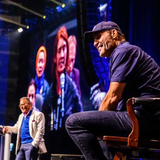 a man sitting in front of a screen that says ' new york ' on it