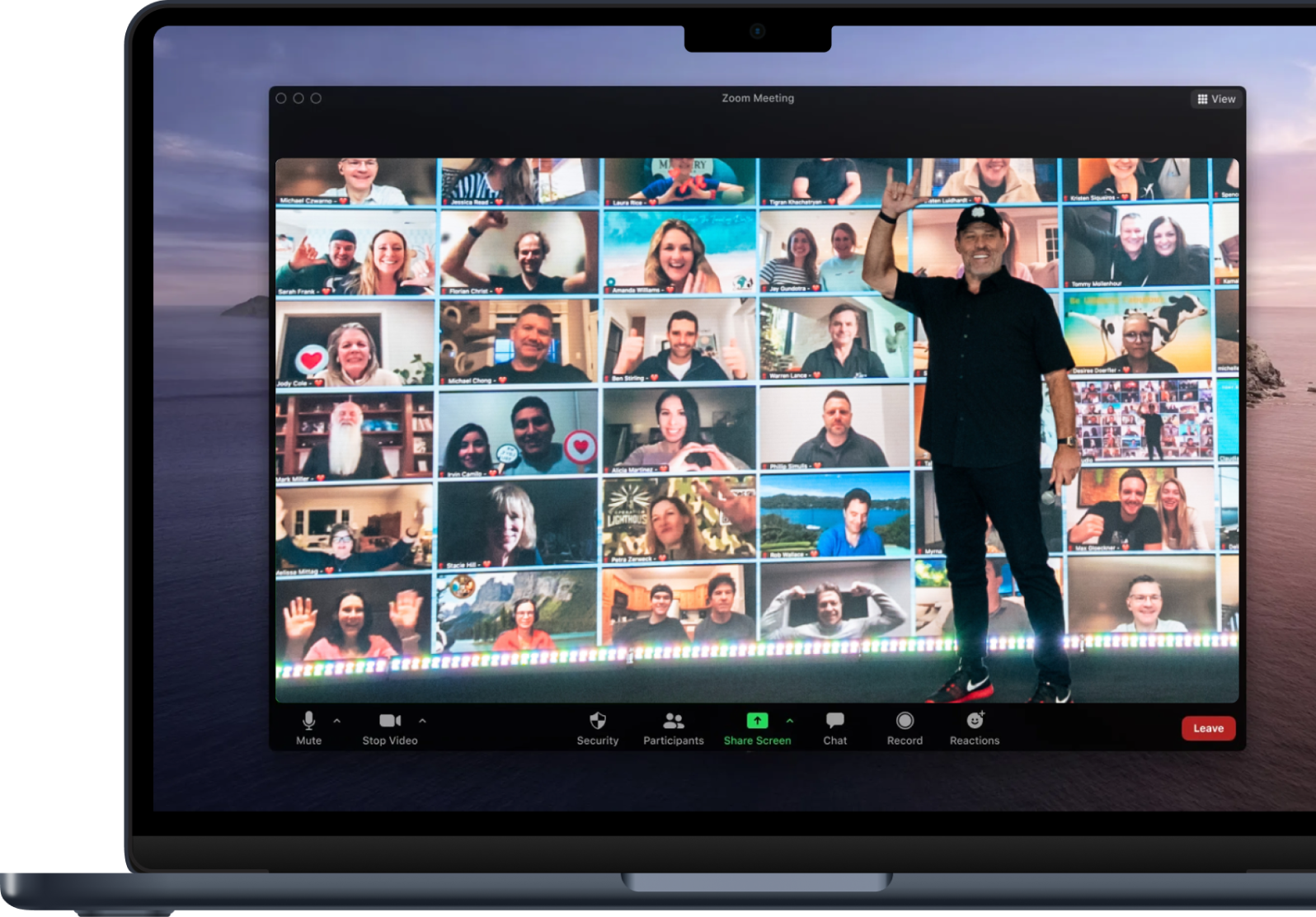 a man stands in front of a screen that says zoom meeting