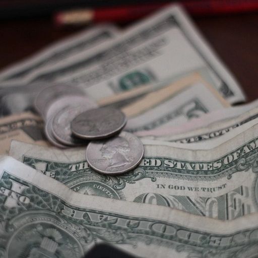 a pile of money and coins on a table .