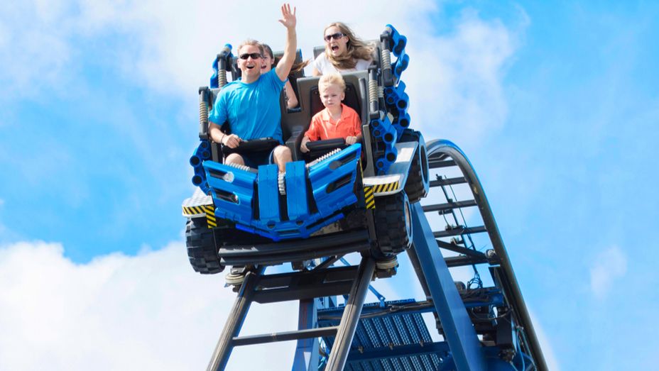 a family is riding a roller coaster at an amusement park .