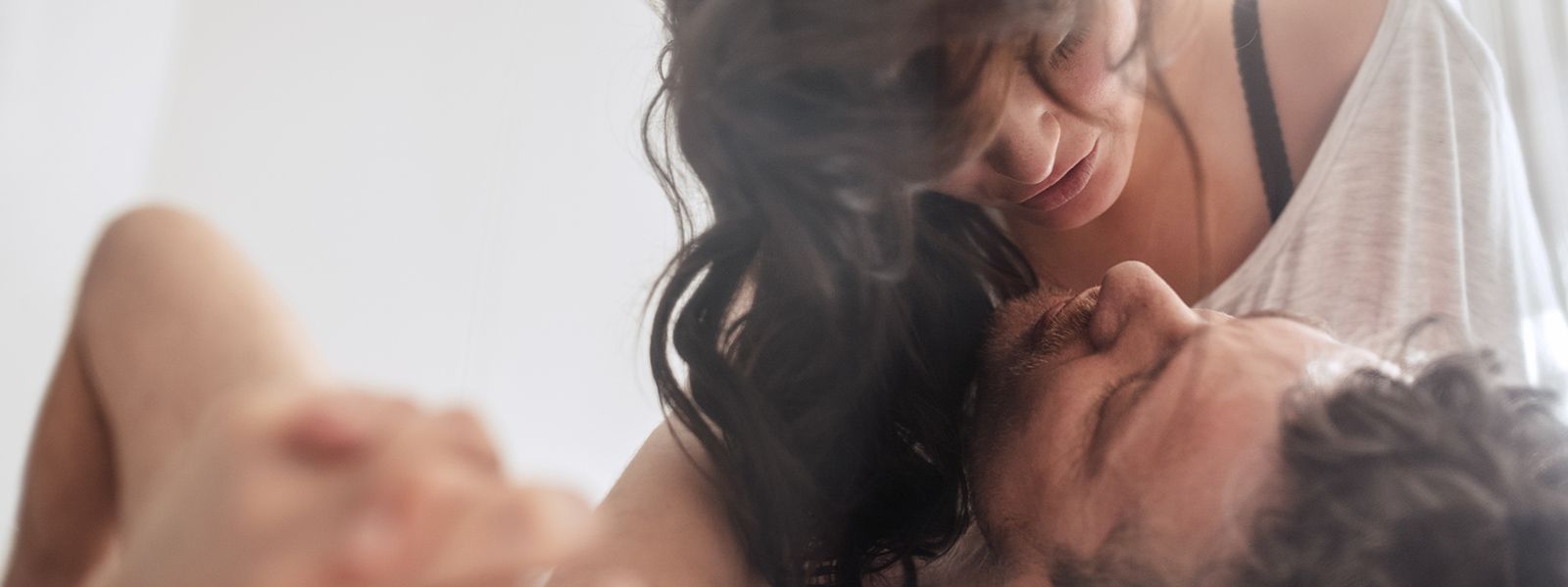 a woman is kissing a man on the forehead .