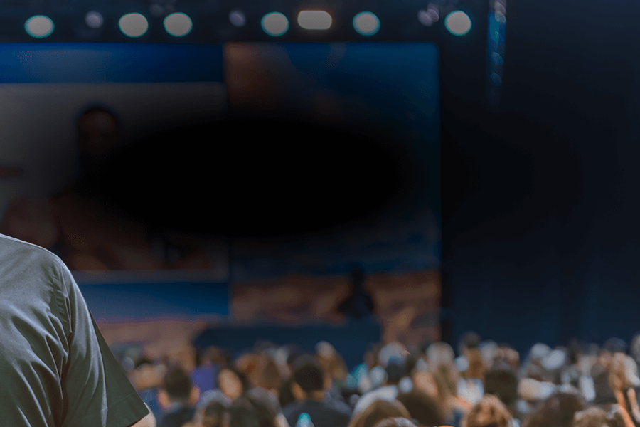 a man in a black shirt is smiling in front of a crowd