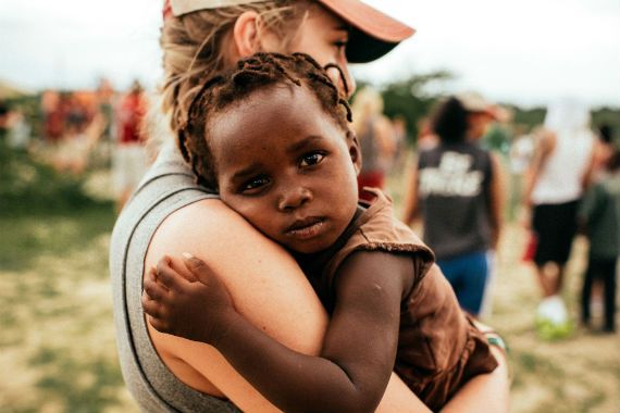 a woman is holding a small child in her arms .