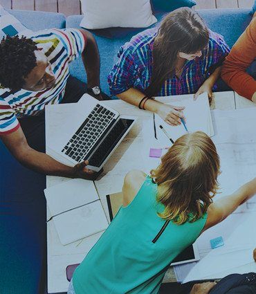 Embracing the 7 Forces of Business Mastery image of office workers around a table