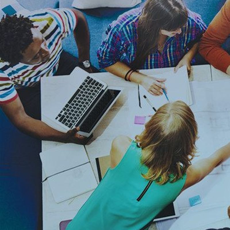 Embracing the 7 Forces of Business Mastery image of office workers around a table