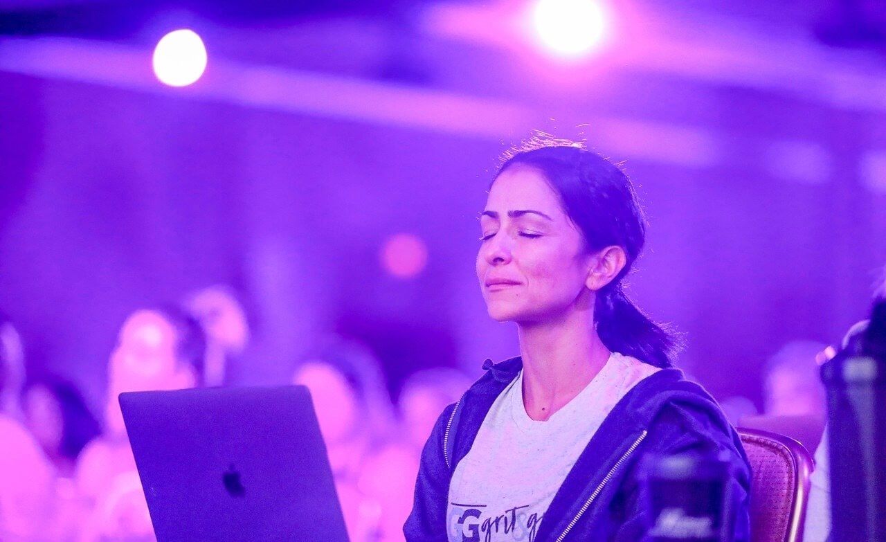 a woman is sitting in front of a laptop computer with her eyes closed .