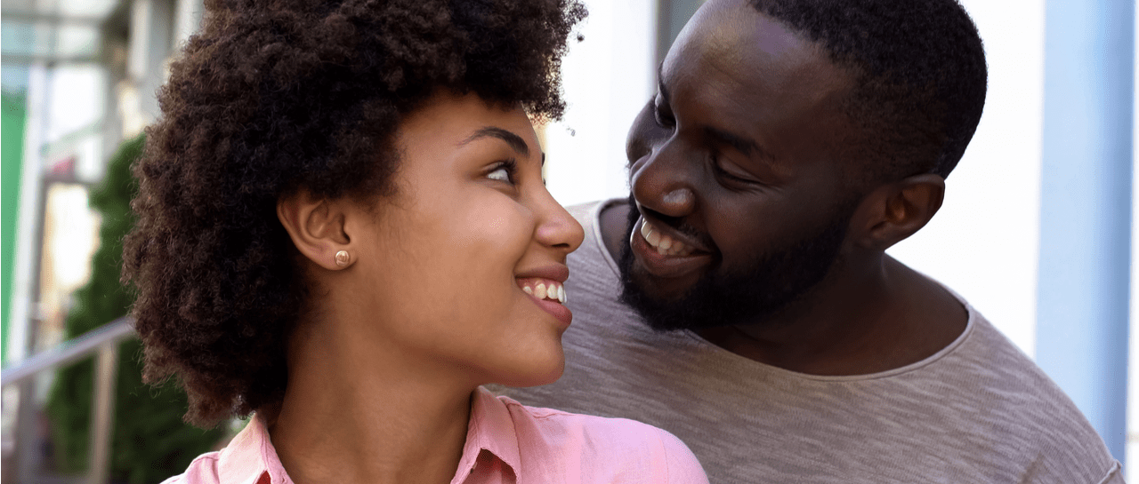 a man and a woman are looking at each other and smiling