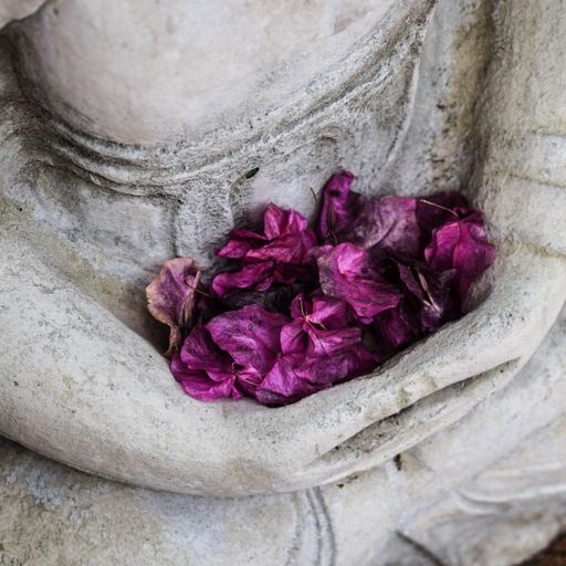 a statue of a person holding purple flowers in their hands .