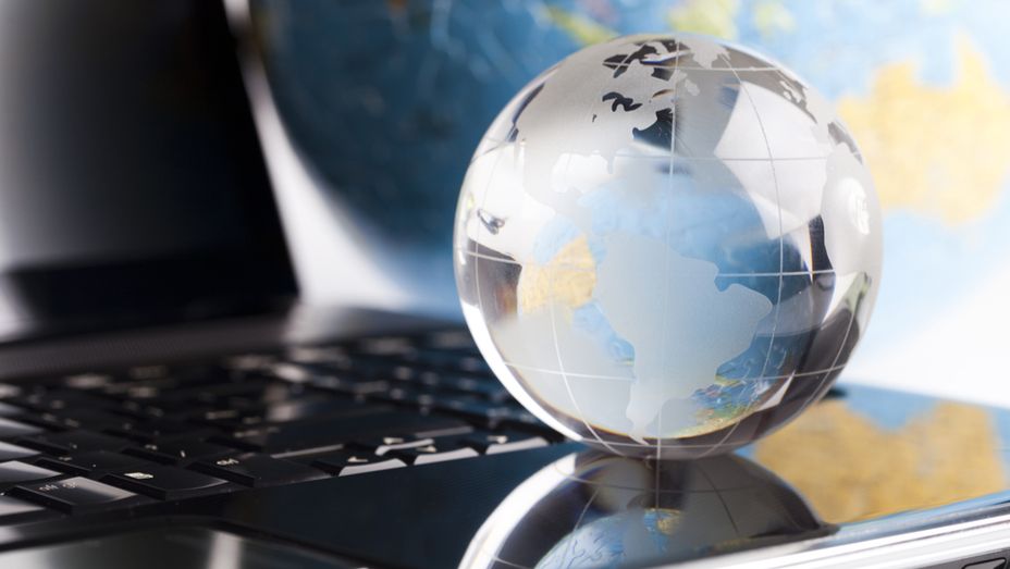 a glass globe is sitting on top of a laptop computer .