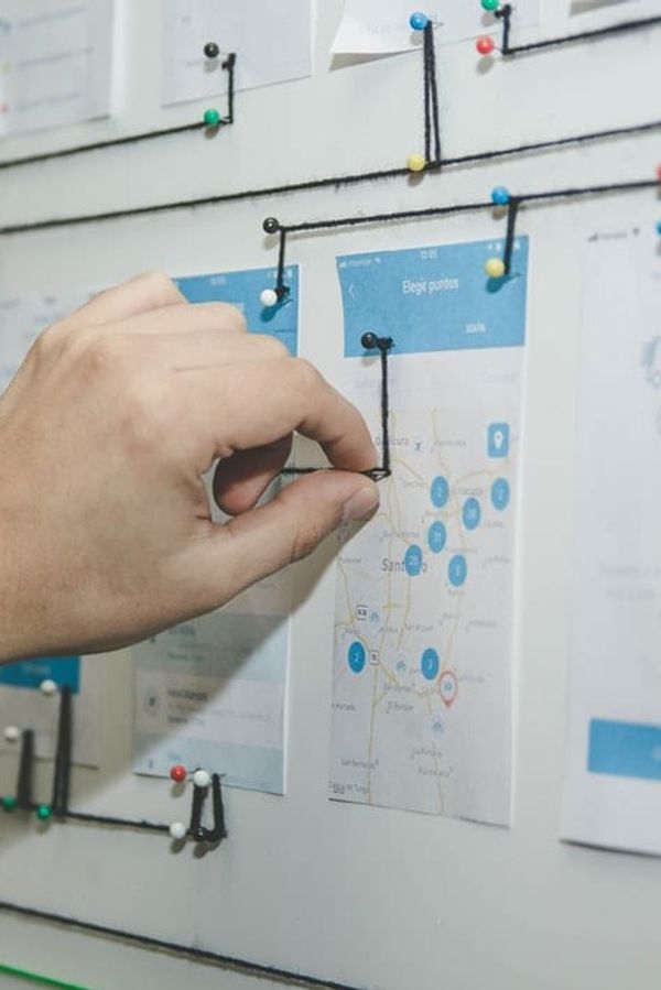 a person is pinning a diagram on a whiteboard .