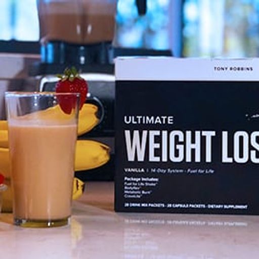 a box of ultimate weight loss is sitting on a counter next to a glass of milk .