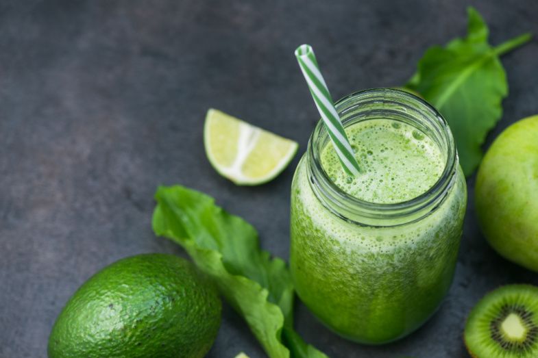 a green smoothie in a mason jar with a straw .