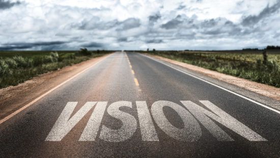 the word vision is painted on the side of a road .