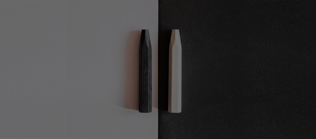 two black and white pens are sitting next to each other on a black and white surface .