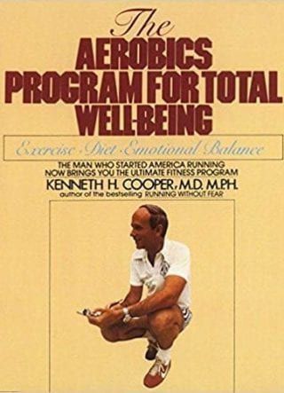 a man is squatting down on the cover of a book titled the aerobics program for total wellbeing .