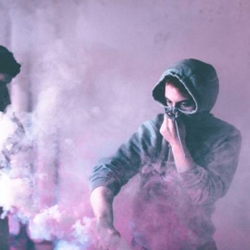 two men are standing in a room with smoke coming out of their mouths .