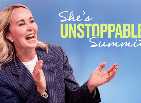 a woman stands in front of a sign that says she 's unstoppable summit