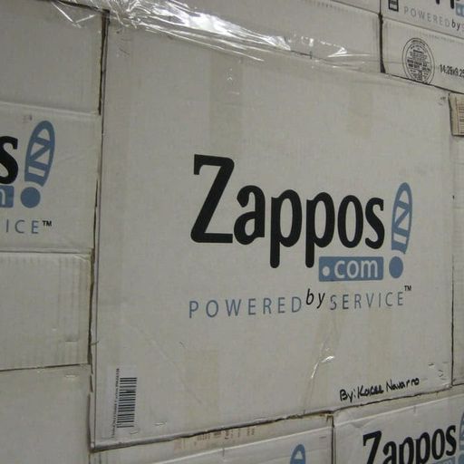 a wall of zappos boxes stacked on top of each other .