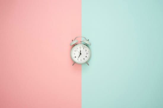 an alarm clock is sitting on a pink and blue background .