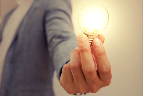 a person is holding a light bulb in their hand .