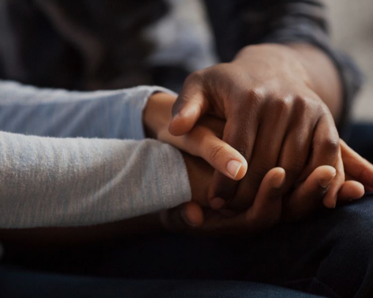 a man and a woman are holding hands while sitting on the floor .
