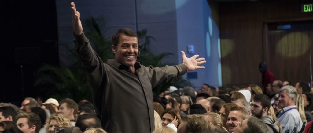 a man is standing in front of a crowd with his arms outstretched